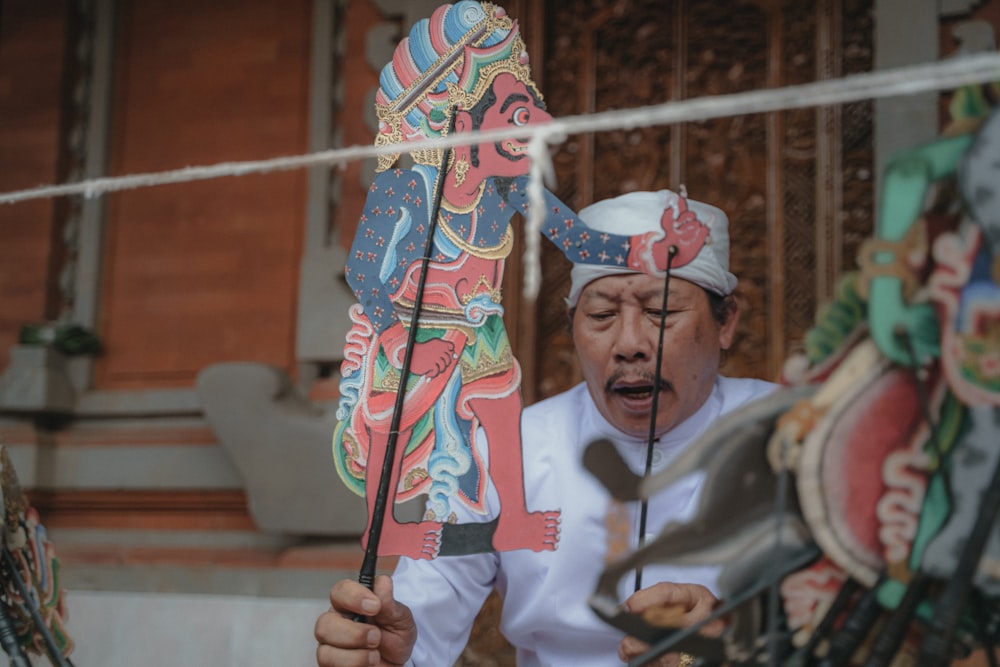 a man is holding up a dragon puppet