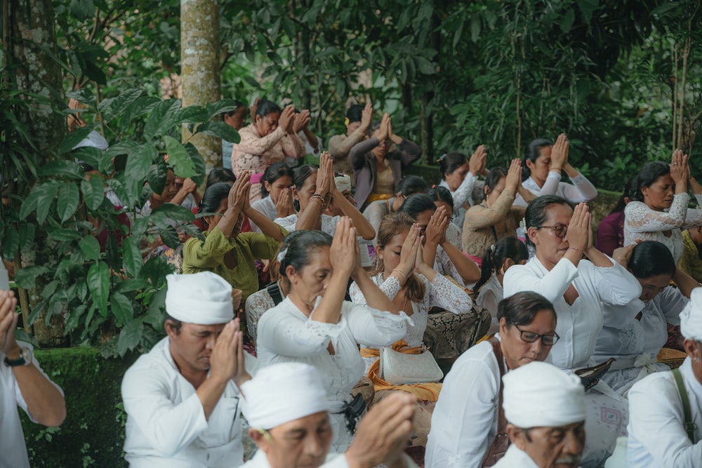 um grande grupo de pessoas sentadas em uma floresta