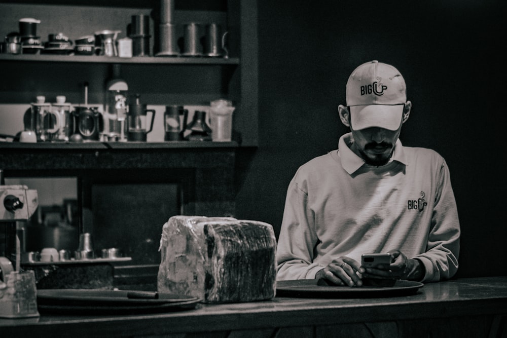 a man in a hat is working on a piece of meat