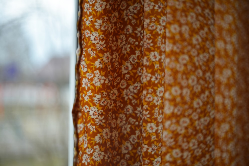 a close up of a curtain with a window in the background