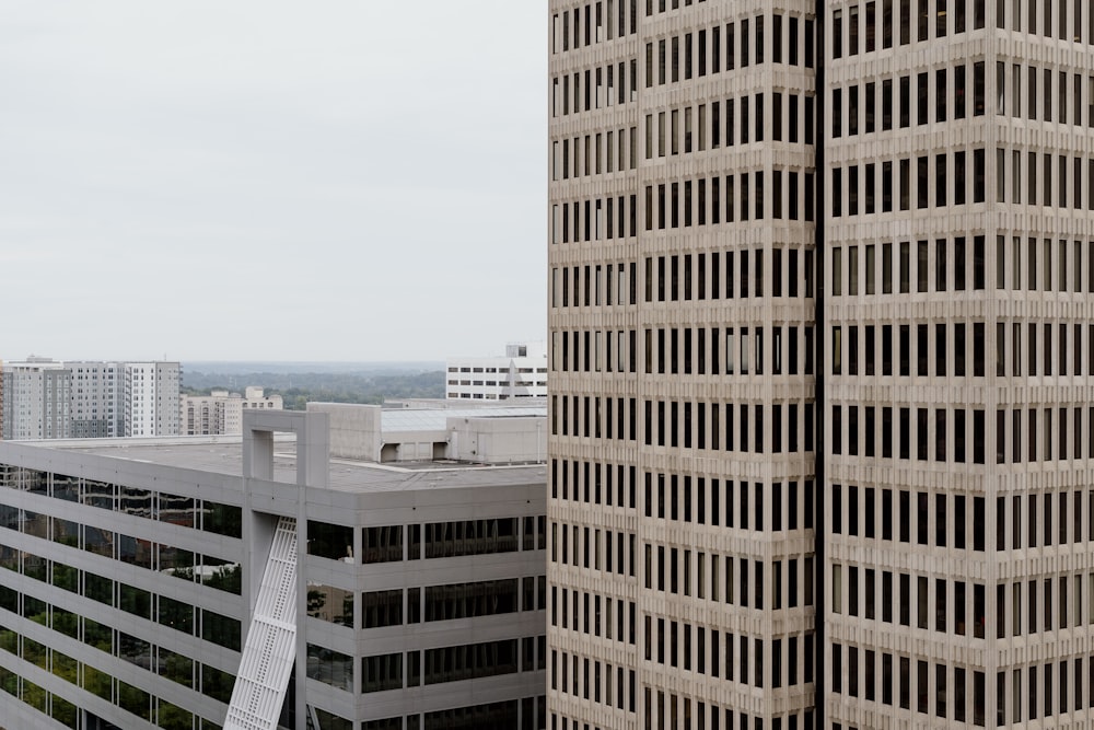 two tall buildings with a sky scraper in the background