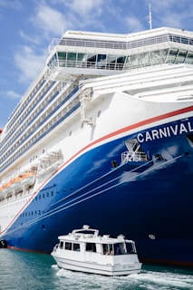 a large cruise ship in the water with a small boat in front of it