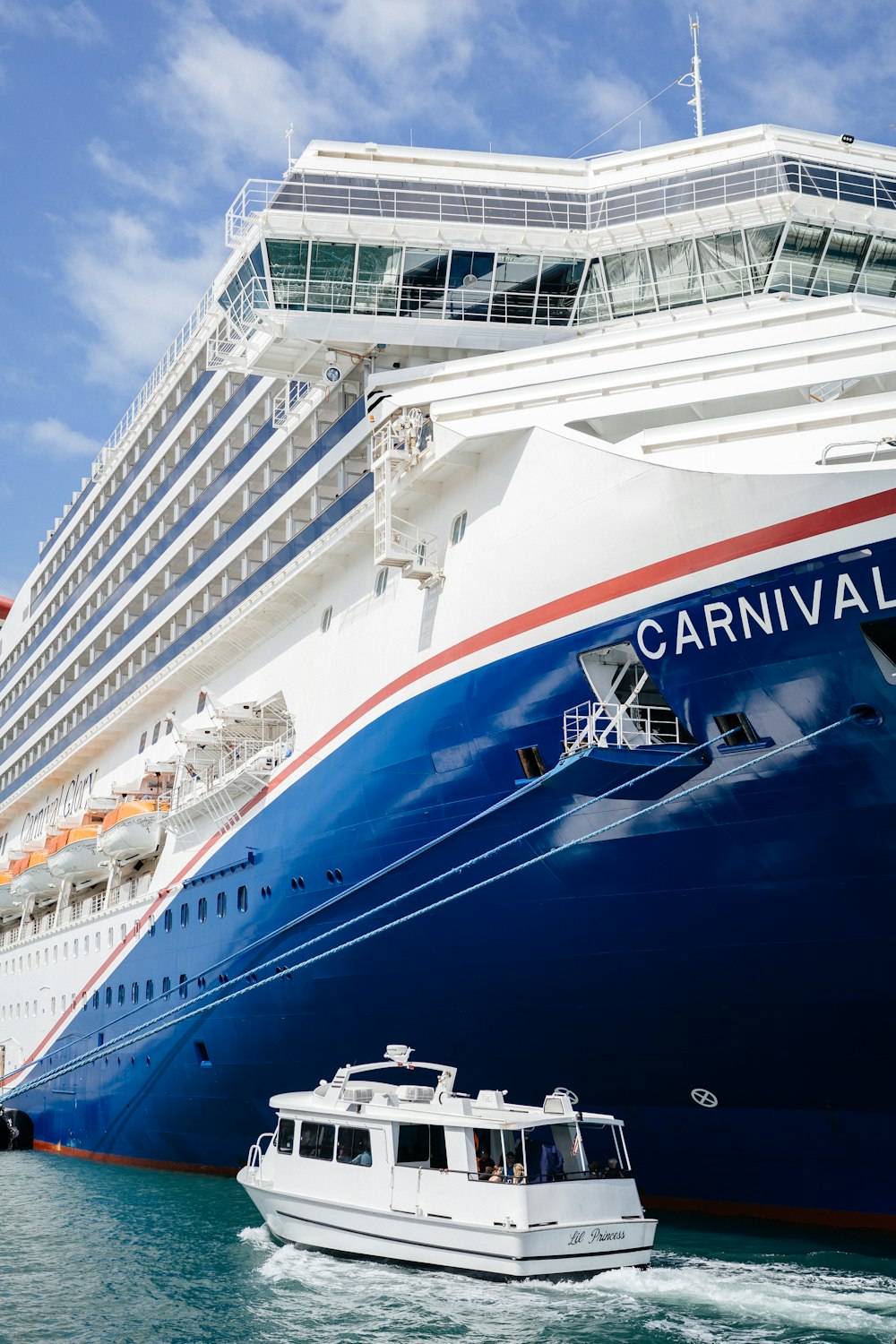 a large cruise ship in the water with a small boat in front of it