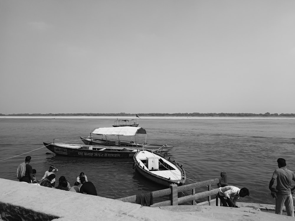 a group of people standing on a dock next to a boat