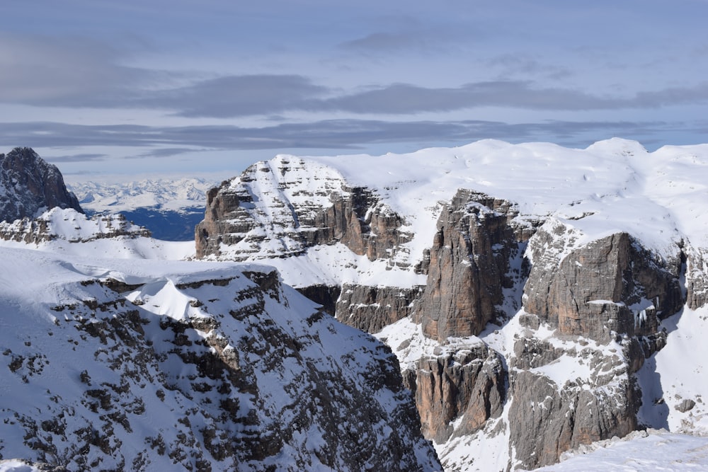 a group of mountains covered in snow under a cloudy sky