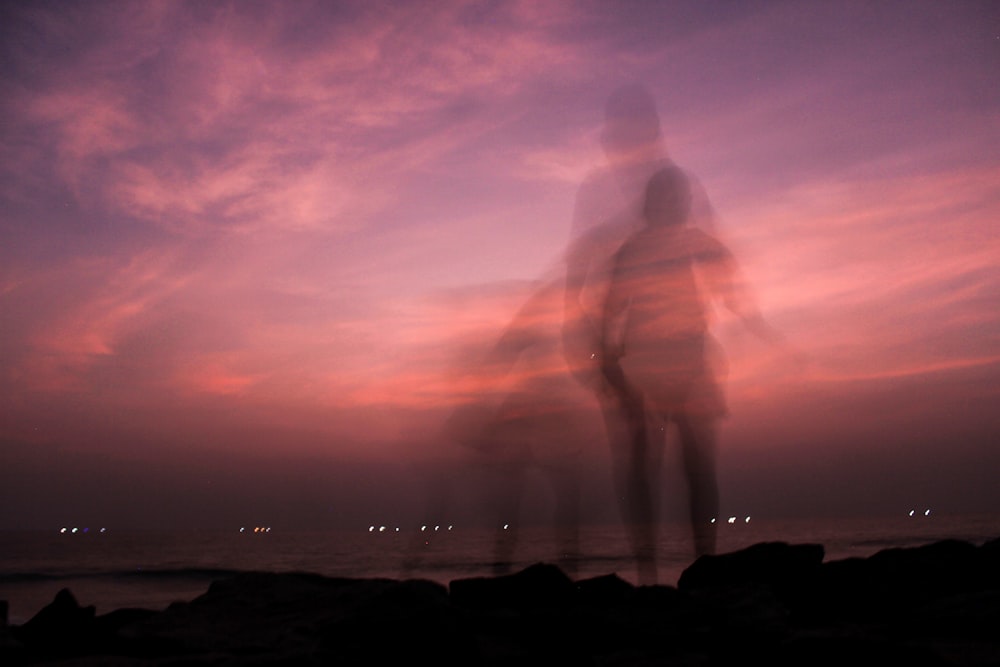 una foto sfocata di una persona in piedi su una spiaggia