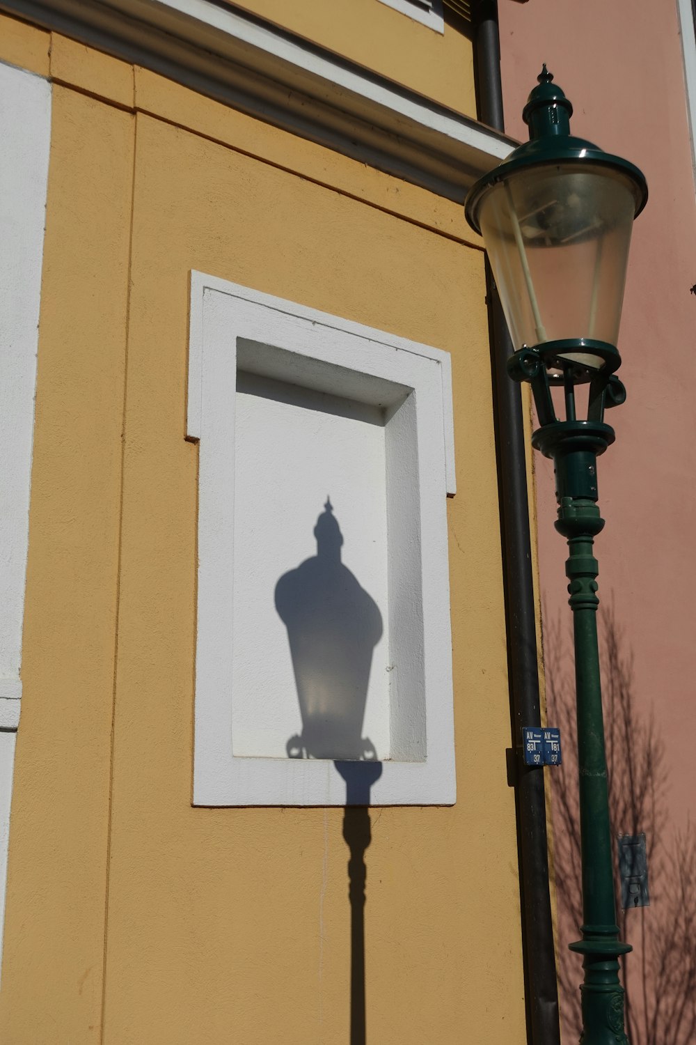 a street light next to a building with a window