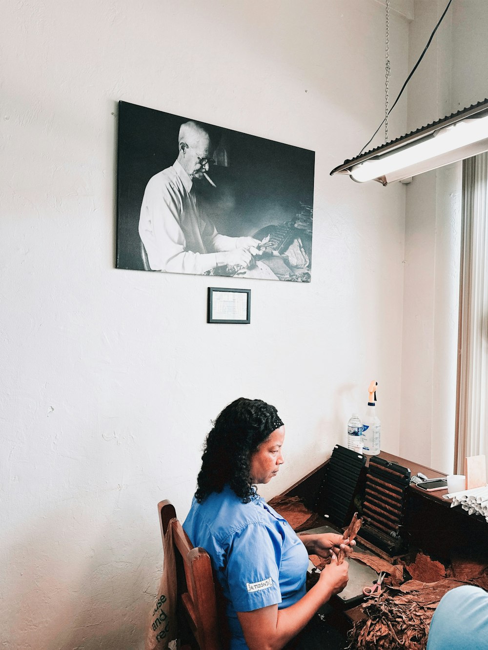 a woman sitting at a desk in front of a window