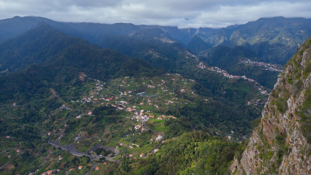 a scenic view of a town nestled in the mountains