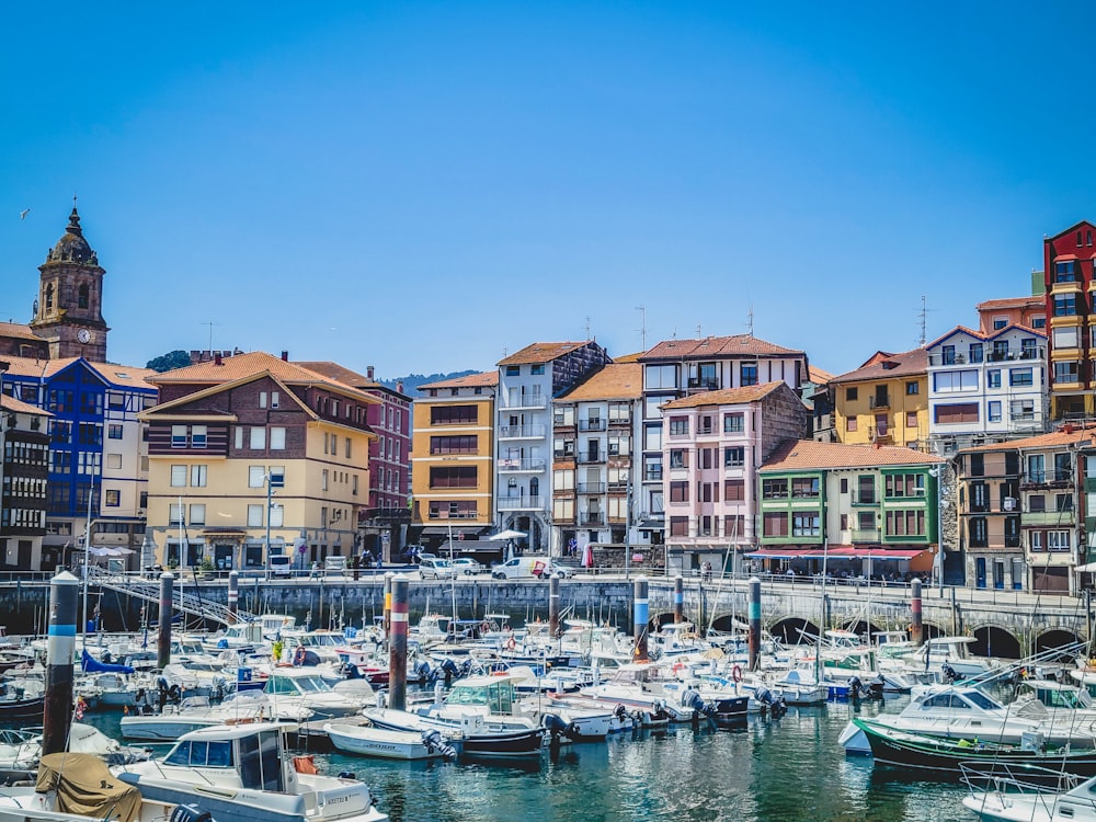 a harbor filled with lots of boats next to tall buildings