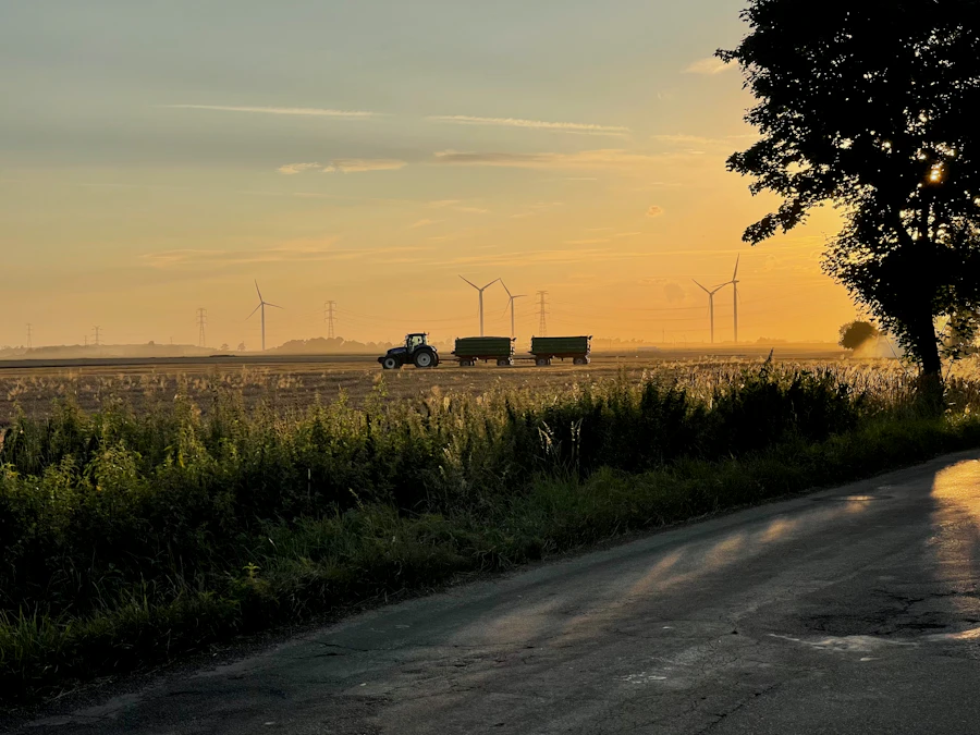 Truck driving along a road beside a green field