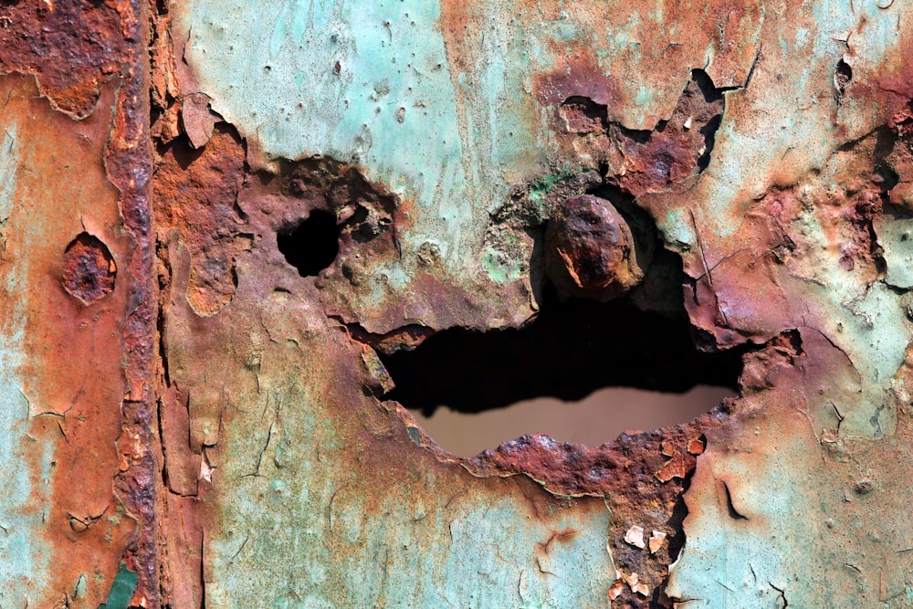 a rusted metal surface with a hole in the middle