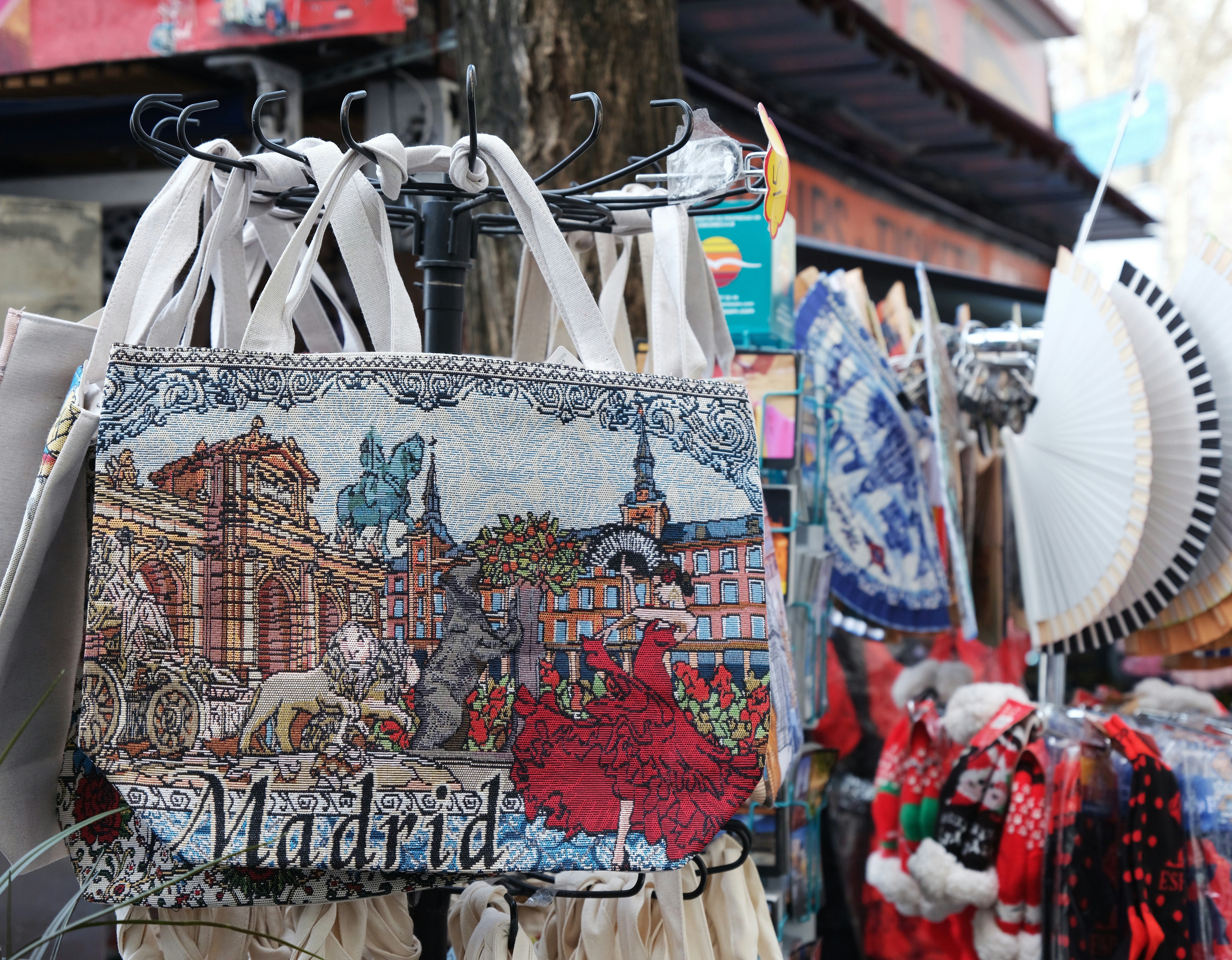 a market with a lot of handbags hanging from it's racks