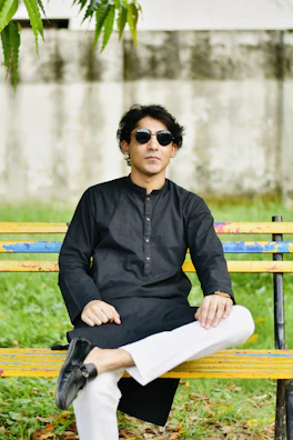 a man sitting on top of a wooden bench