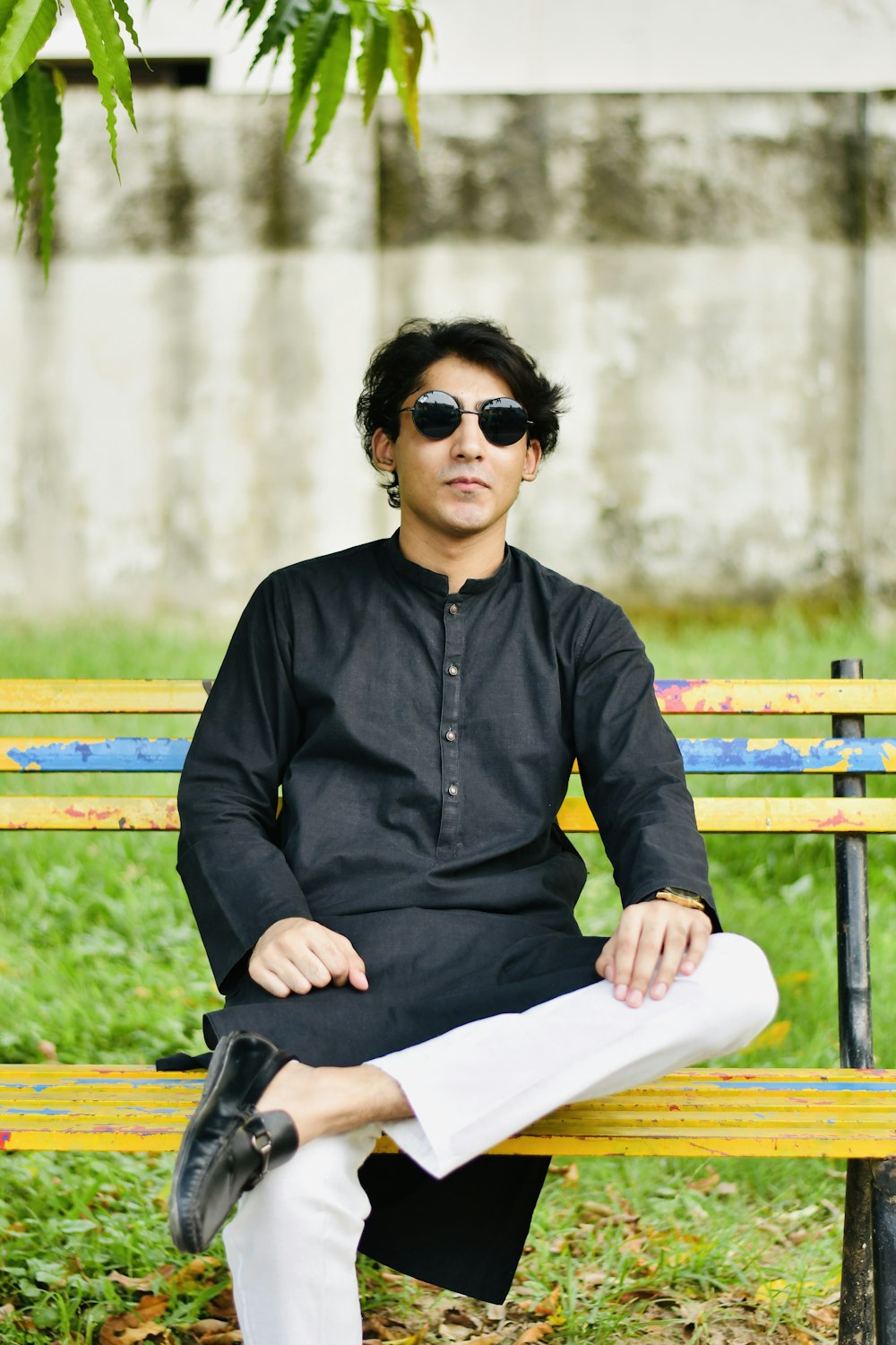 a man sitting on top of a wooden bench