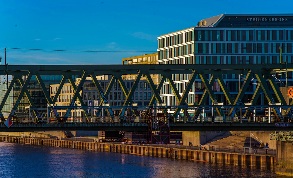 a bridge over a body of water with buildings in the background