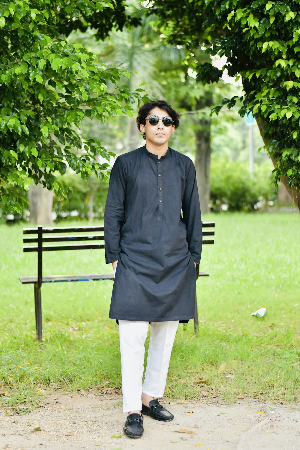 a man standing in front of a park bench