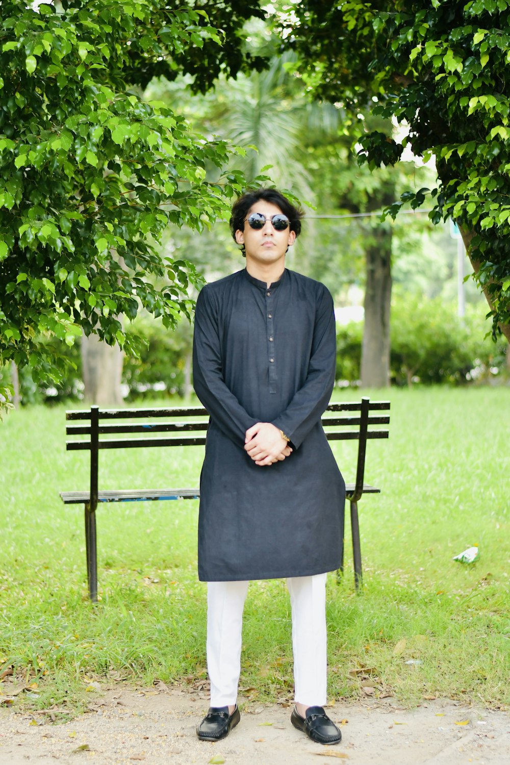 a man standing in front of a park bench