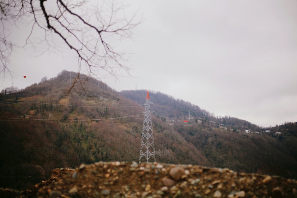 uma vista de uma montanha com uma torre de telefone em primeiro plano