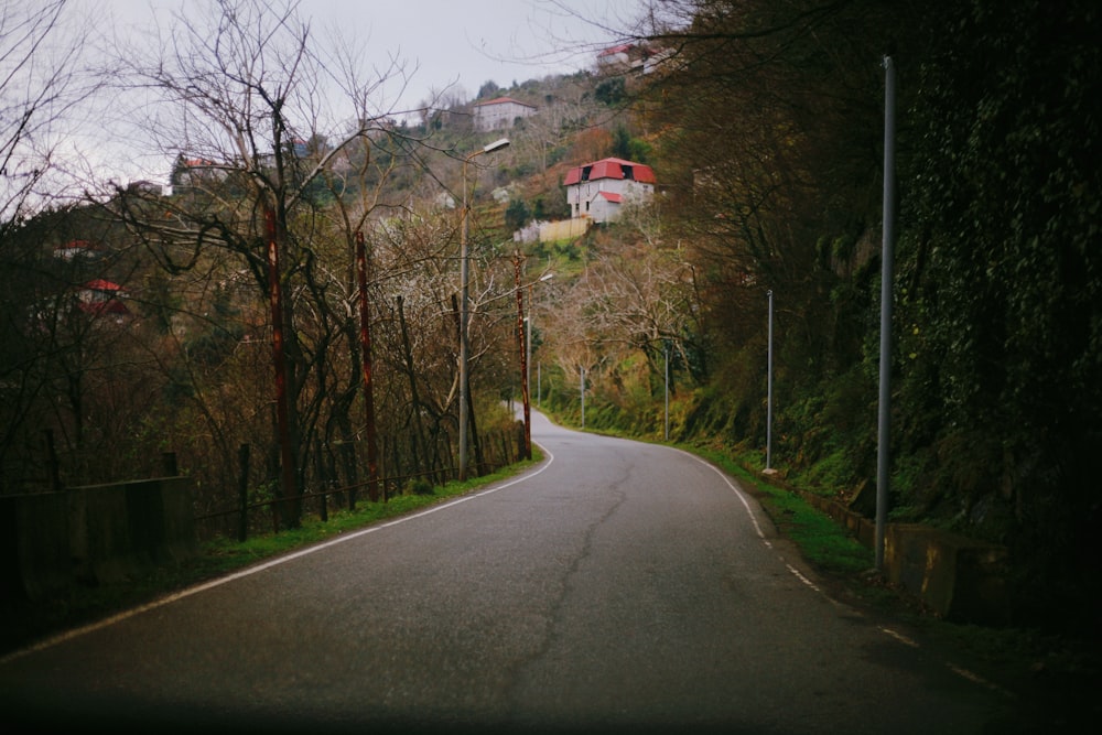 an empty road in the middle of a wooded area