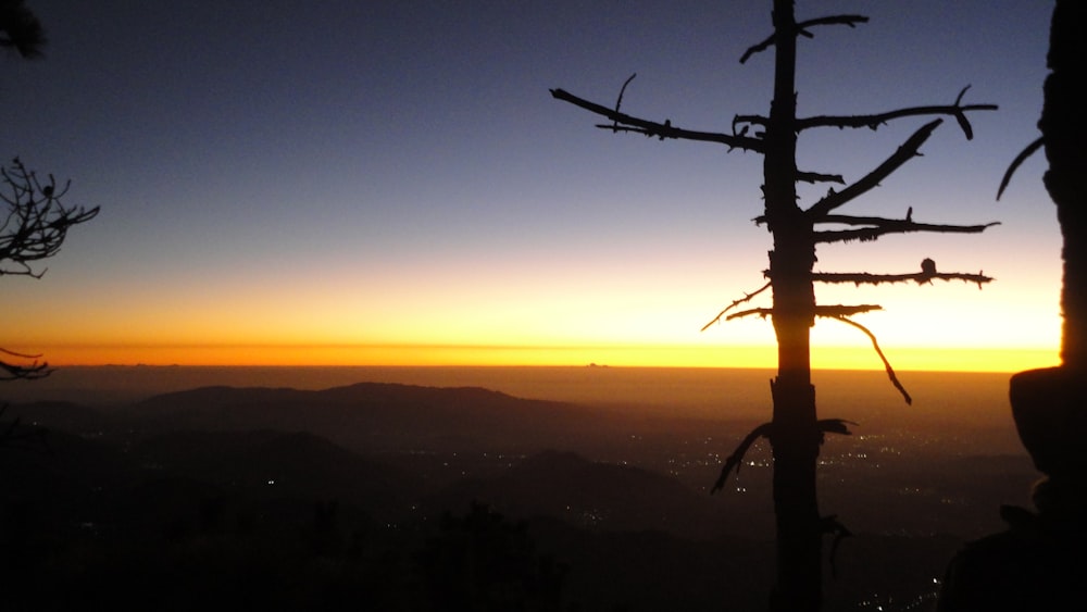 the sun is setting over a mountain range