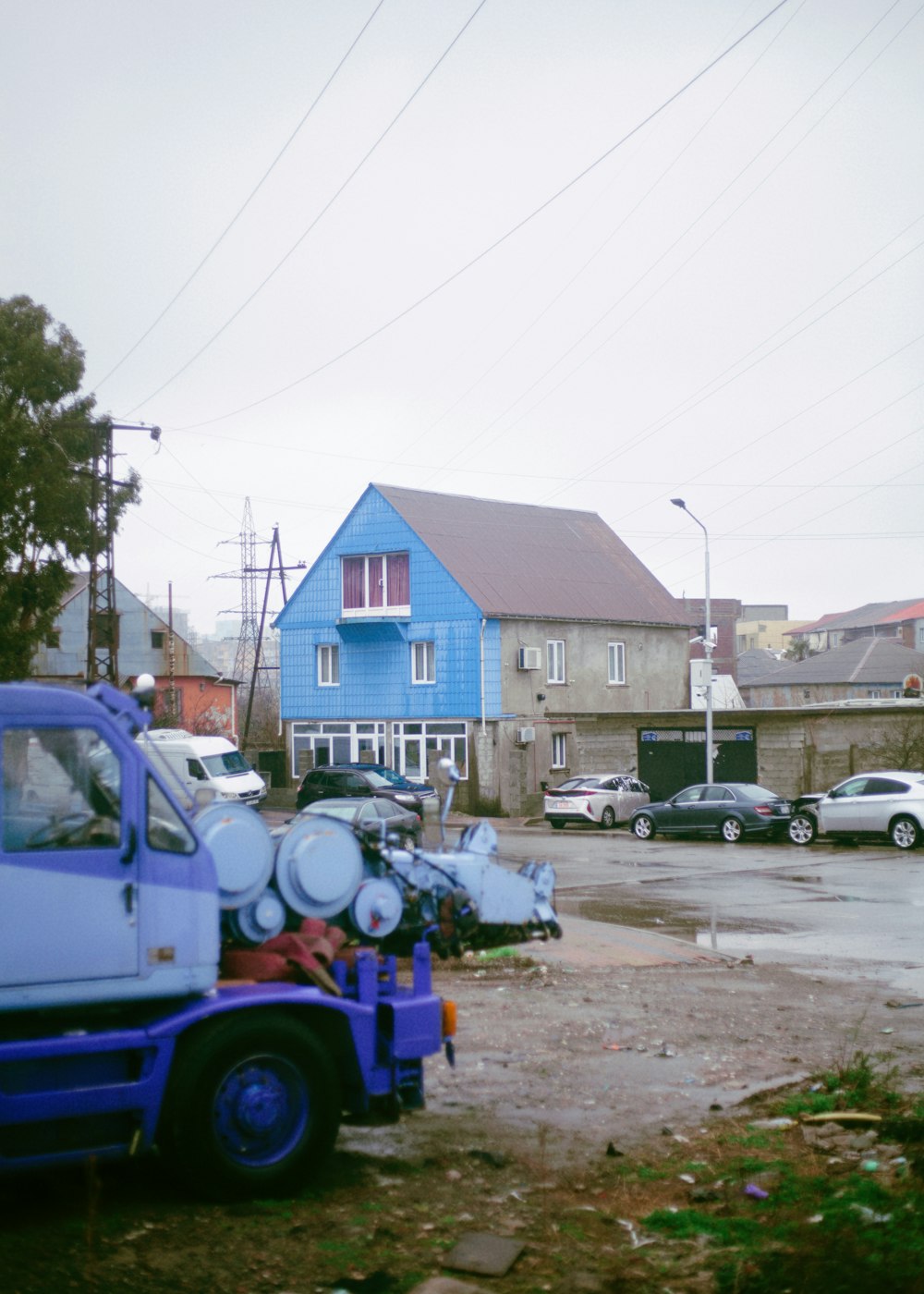 Un camion bleu garé devant une maison bleue