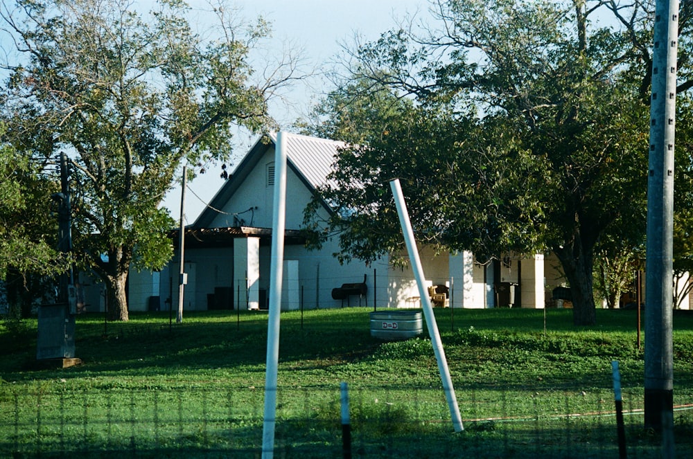 Une maison blanche assise au sommet d’un champ verdoyant