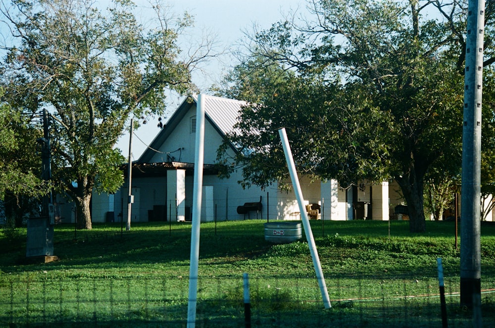 a white house sitting on top of a lush green field