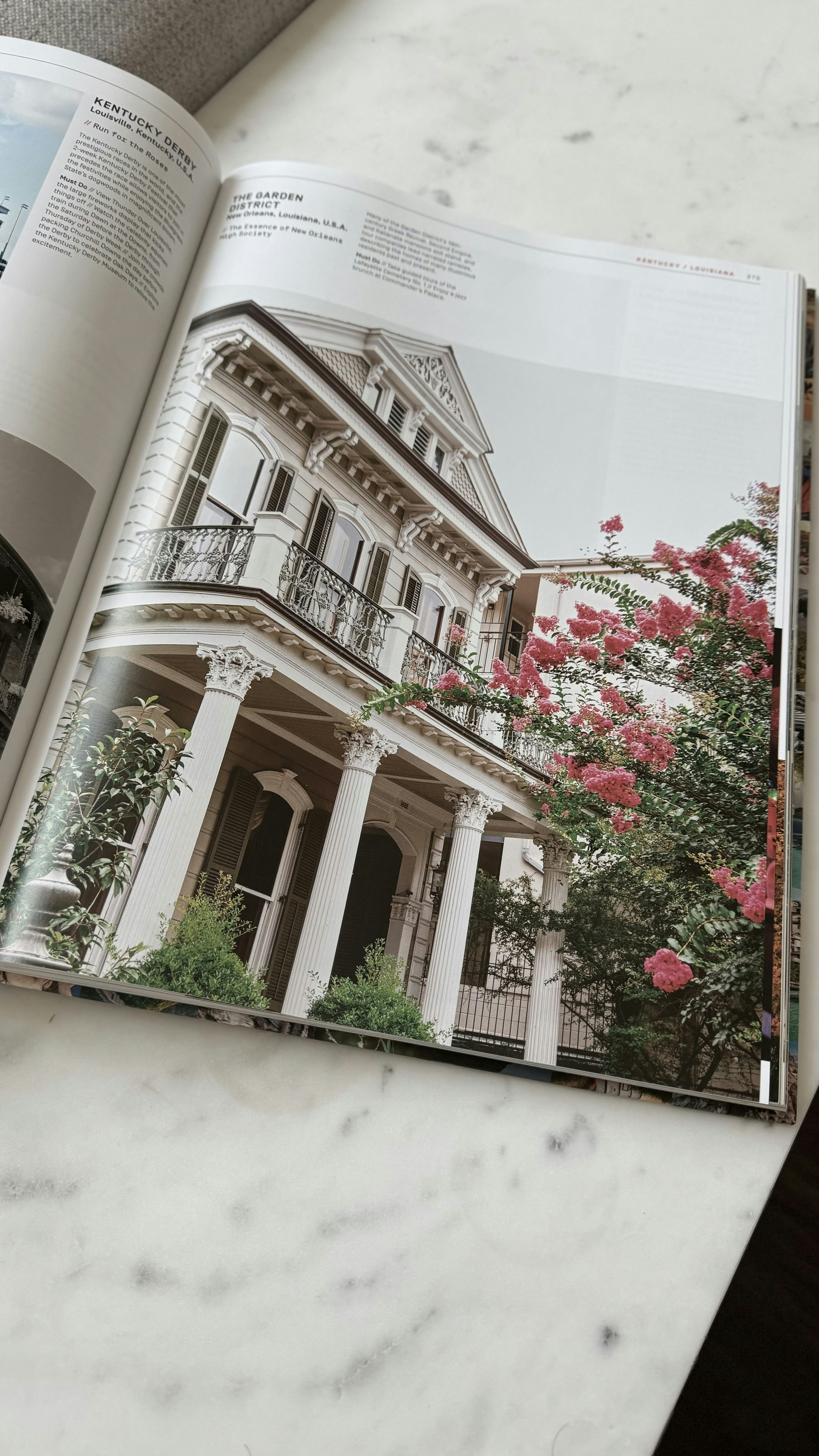 Grand southern estate with white columns, sweeping veranda, magnolia trees, manicured gardens, blue sky