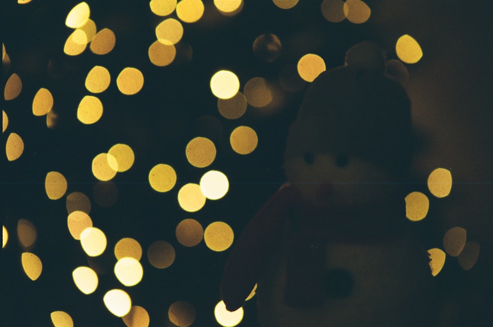 a teddy bear that is sitting in front of a christmas tree