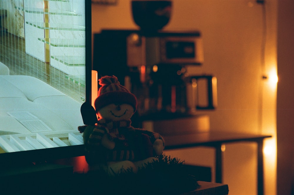 a teddy bear sitting in front of a television