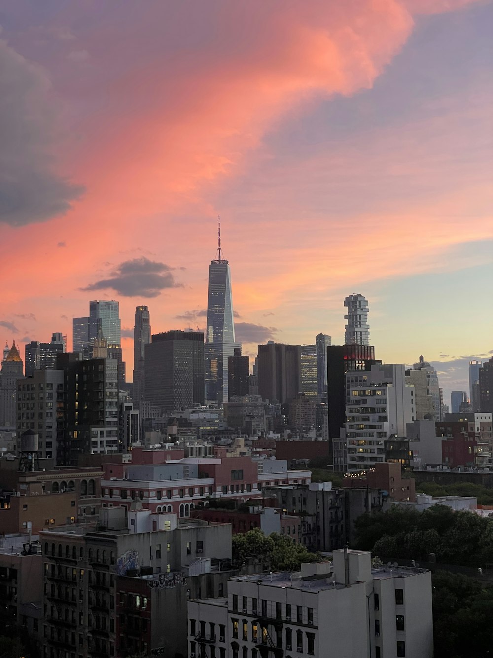 a sunset view of a city with tall buildings