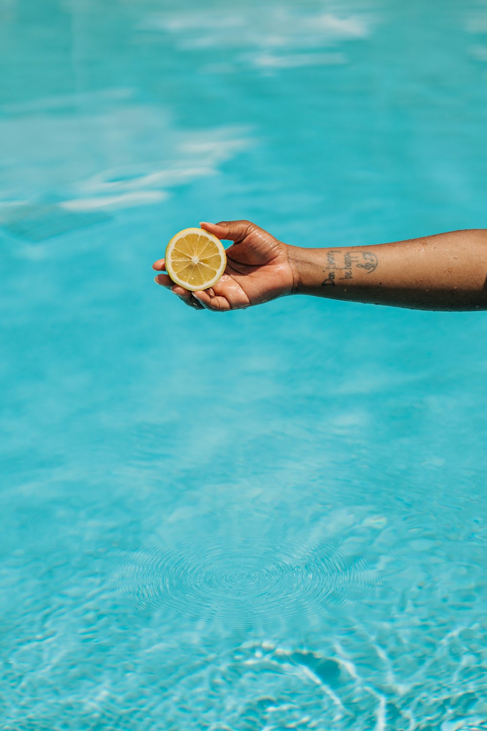 a person holding a slice of lemon in their hand