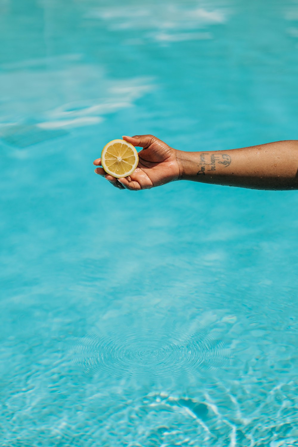 una persona sosteniendo una rodaja de limón en la mano