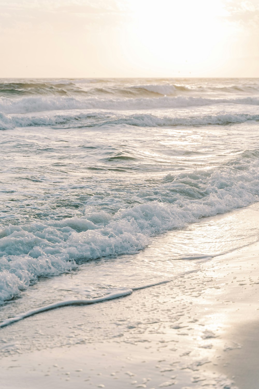 a person walking on the beach with a surfboard