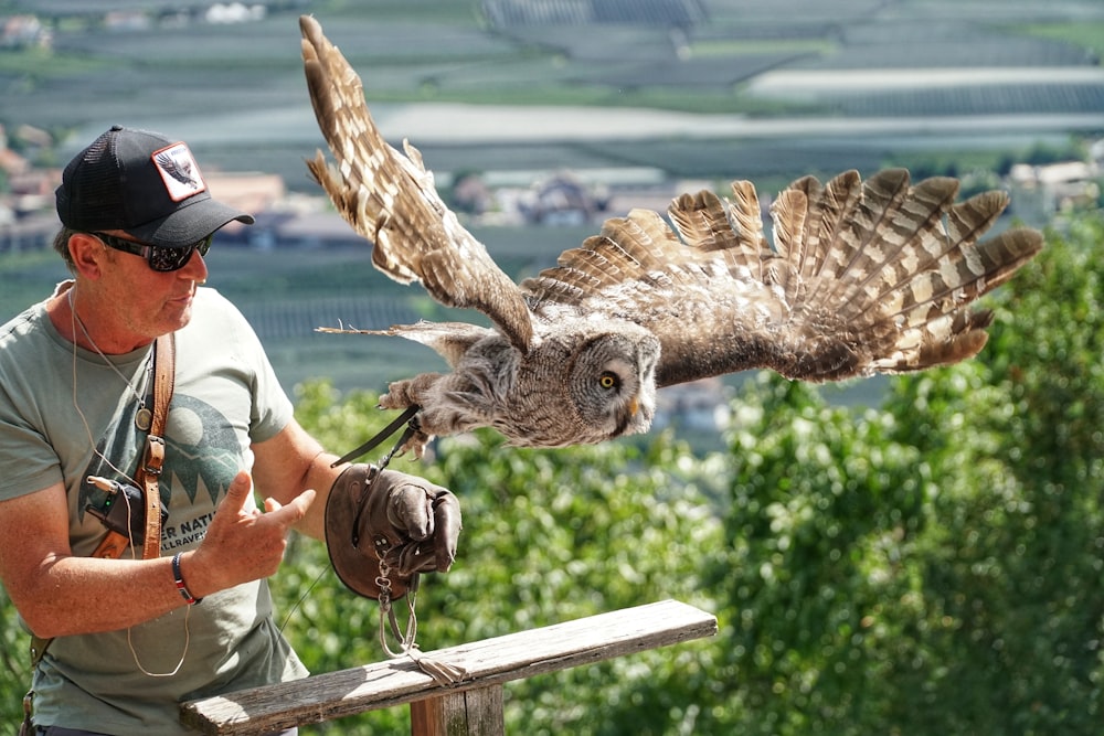 a man holding a bird of prey in his right hand