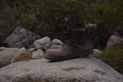 a pair of brown boots sitting on top of a rock