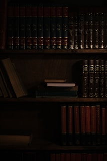 a bookshelf filled with lots of books in a dark room