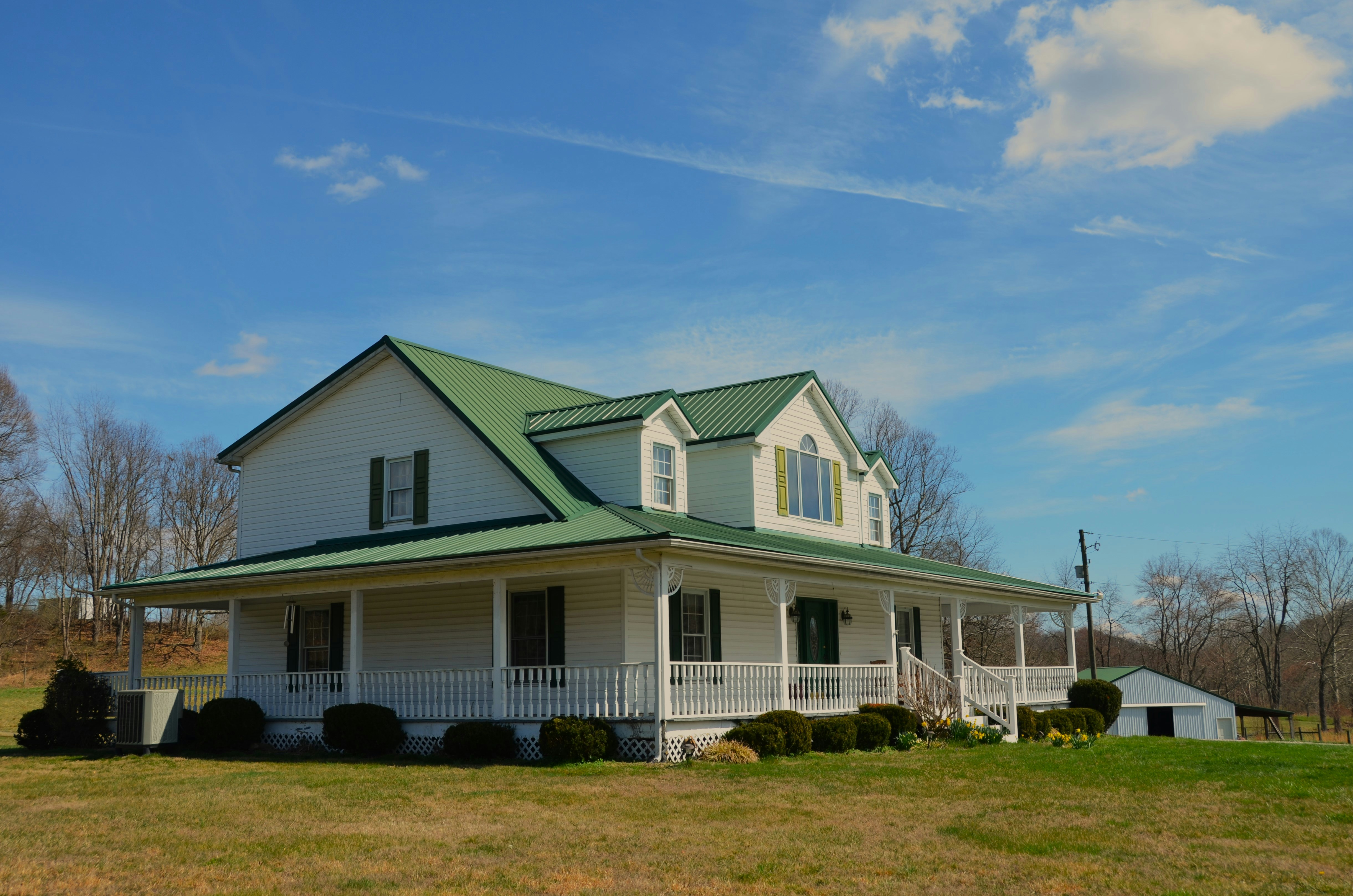 Modern farmhouse with wrap aound porch in white and green