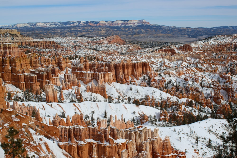 a snow covered landscape with a mountain range in the background