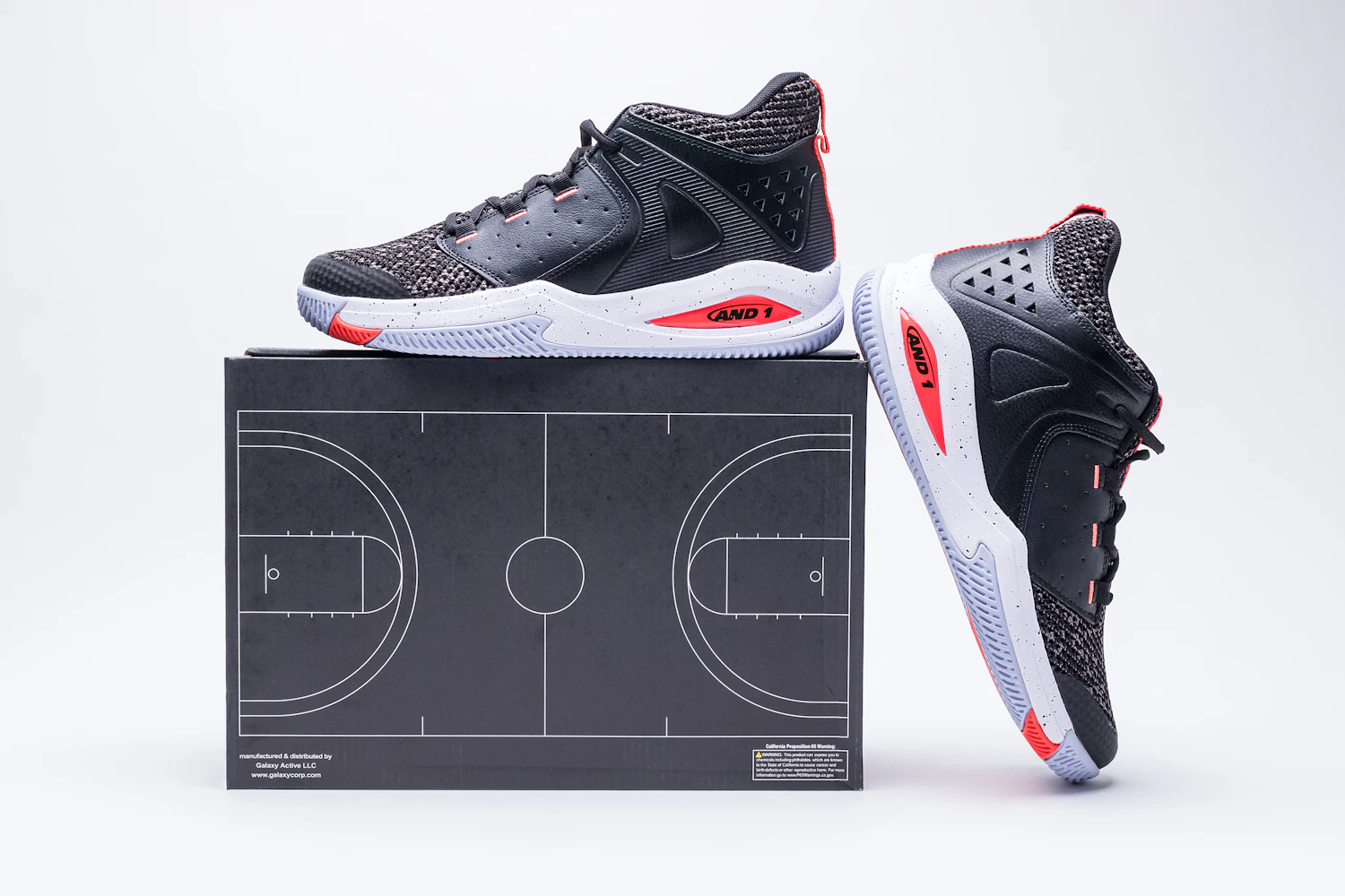 Black and red basketball shoes on a box printed with a court