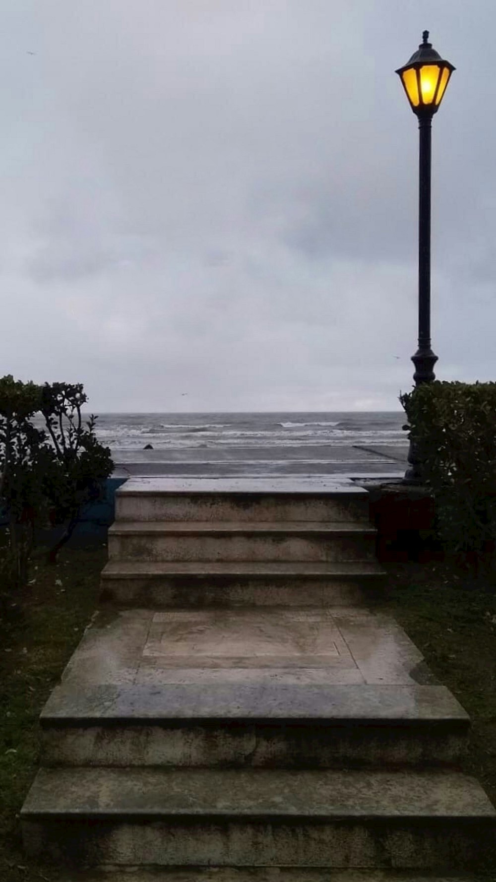 a street light sitting on the side of a set of steps