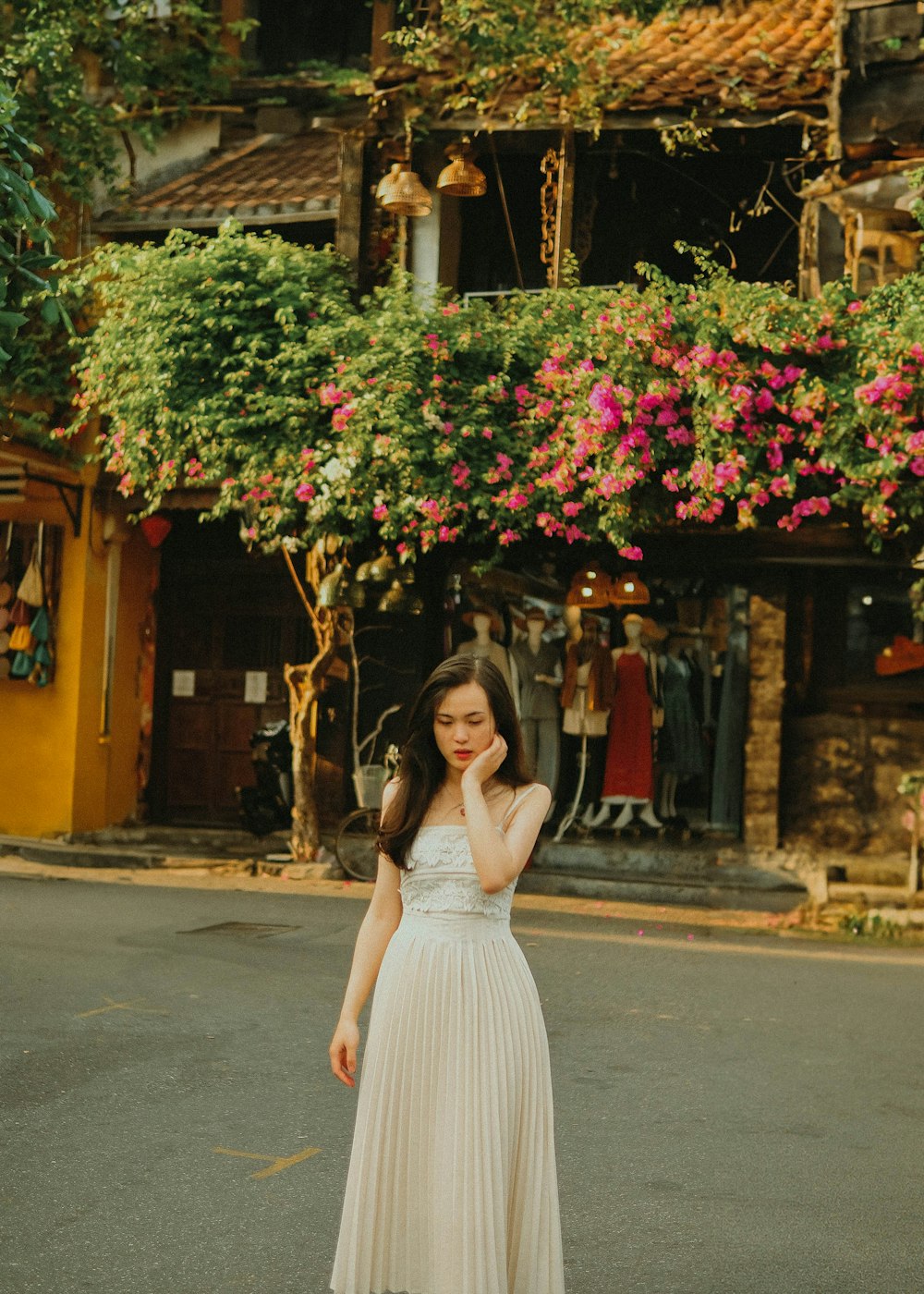 una mujer con un vestido blanco de pie frente a un edificio