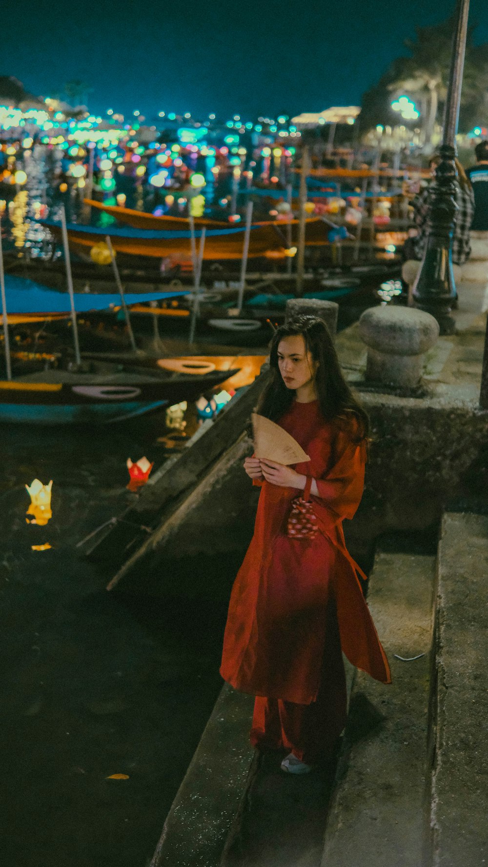a woman in a red dress standing on a dock