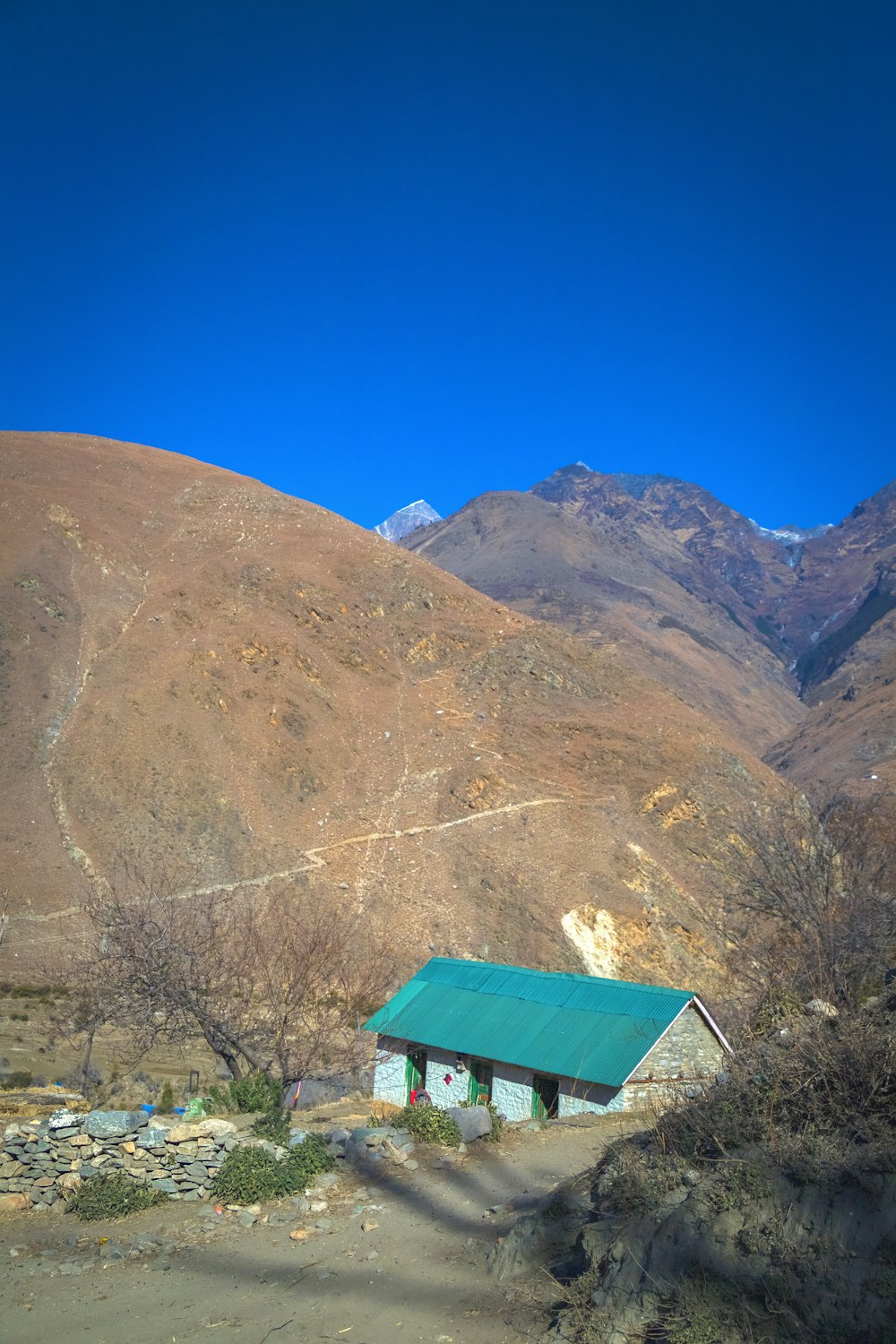 a small house in the middle of a mountain range