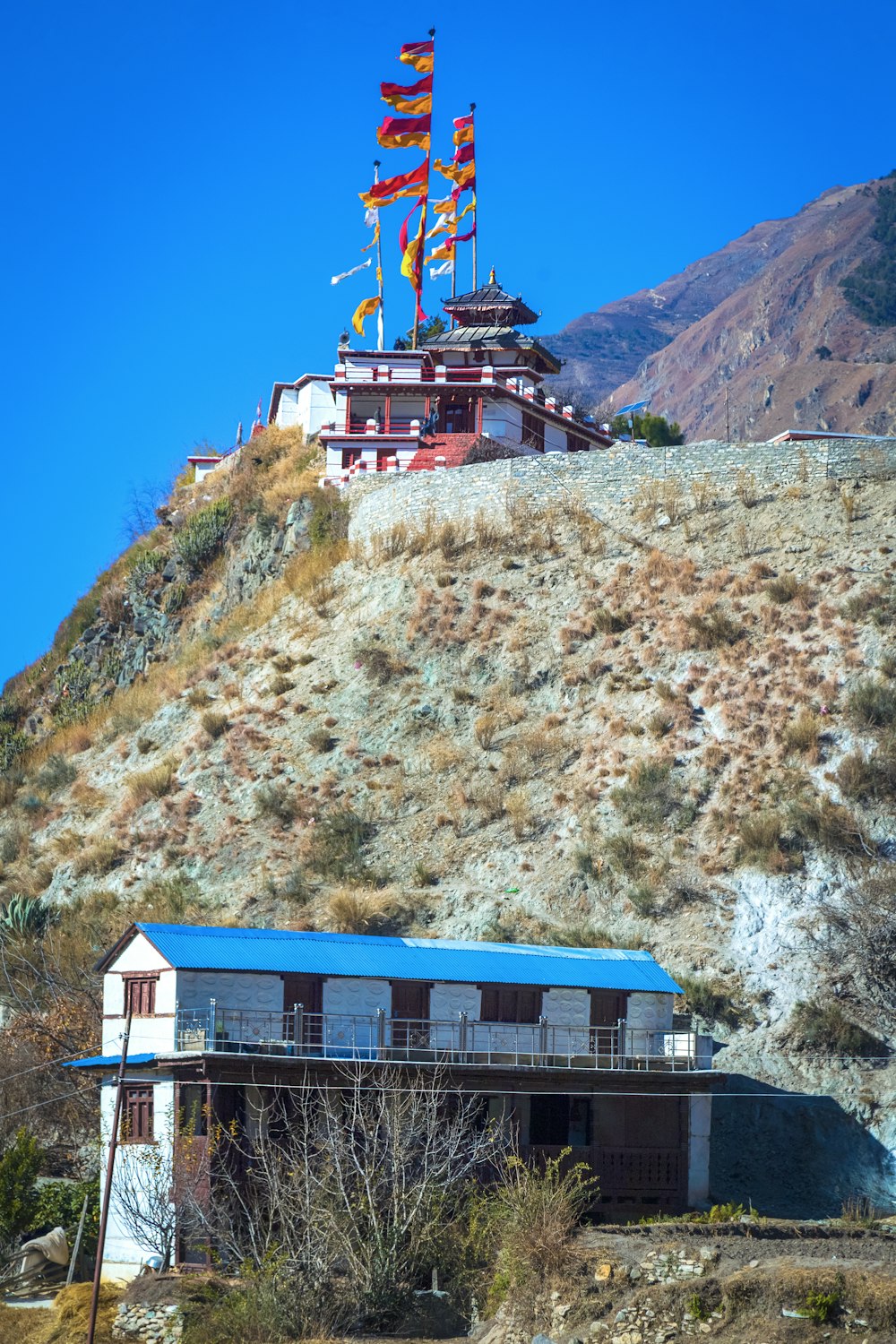 a building on the side of a hill with flags on it