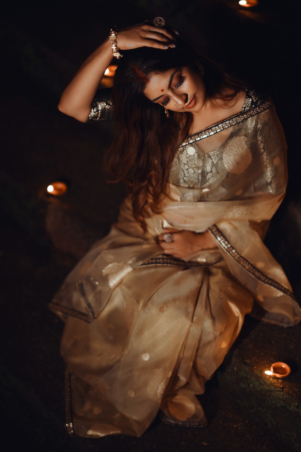a woman sitting on the ground in a sari