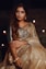 a woman in a white and gold sari