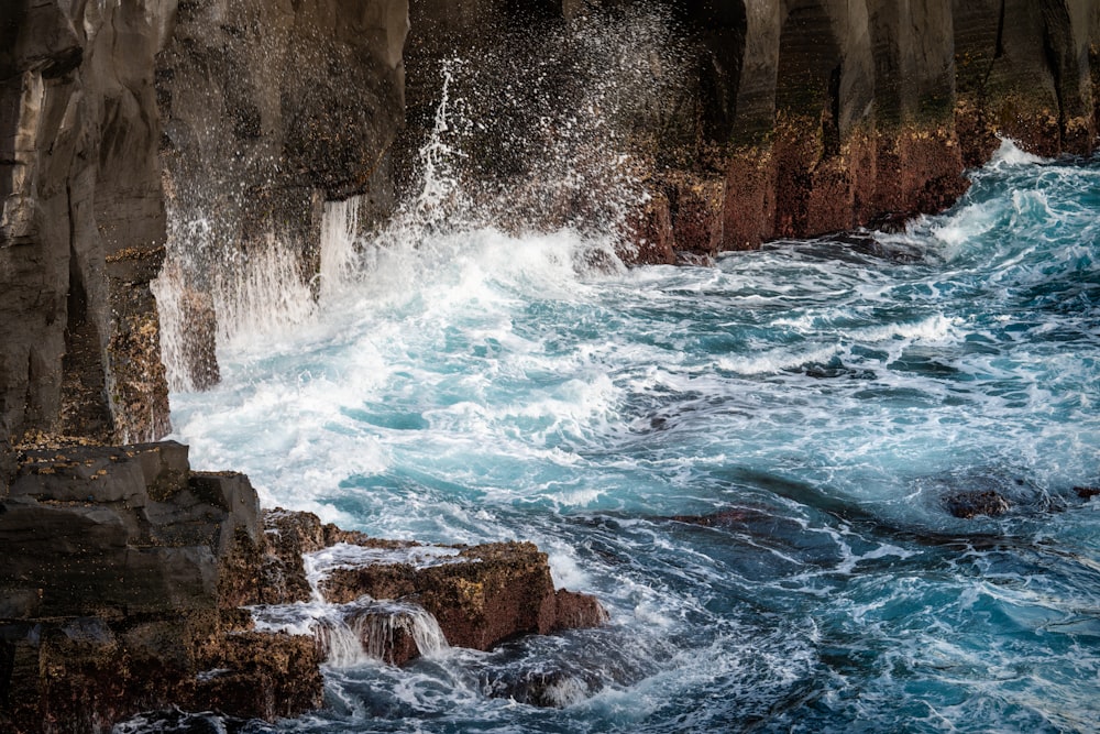 un grande specchio d'acqua accanto a una scogliera rocciosa