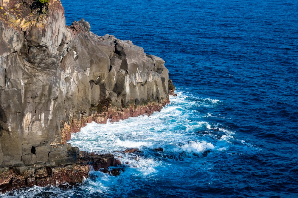 a large rock outcropping in the middle of the ocean
